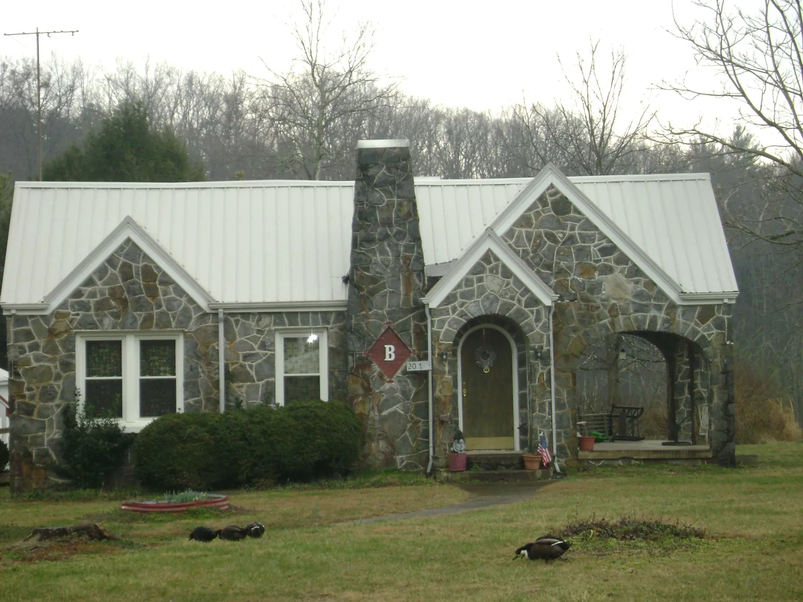 White metal roof on a stone cottage with steep gables in Coolidge